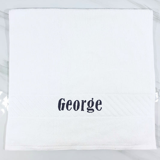 White hand towel with 'George' embroidered on a white background