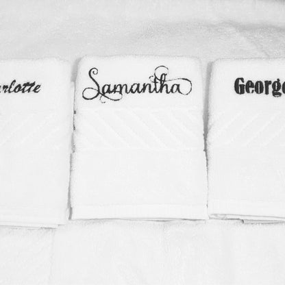 Three white face towels with embroidered names on a white background