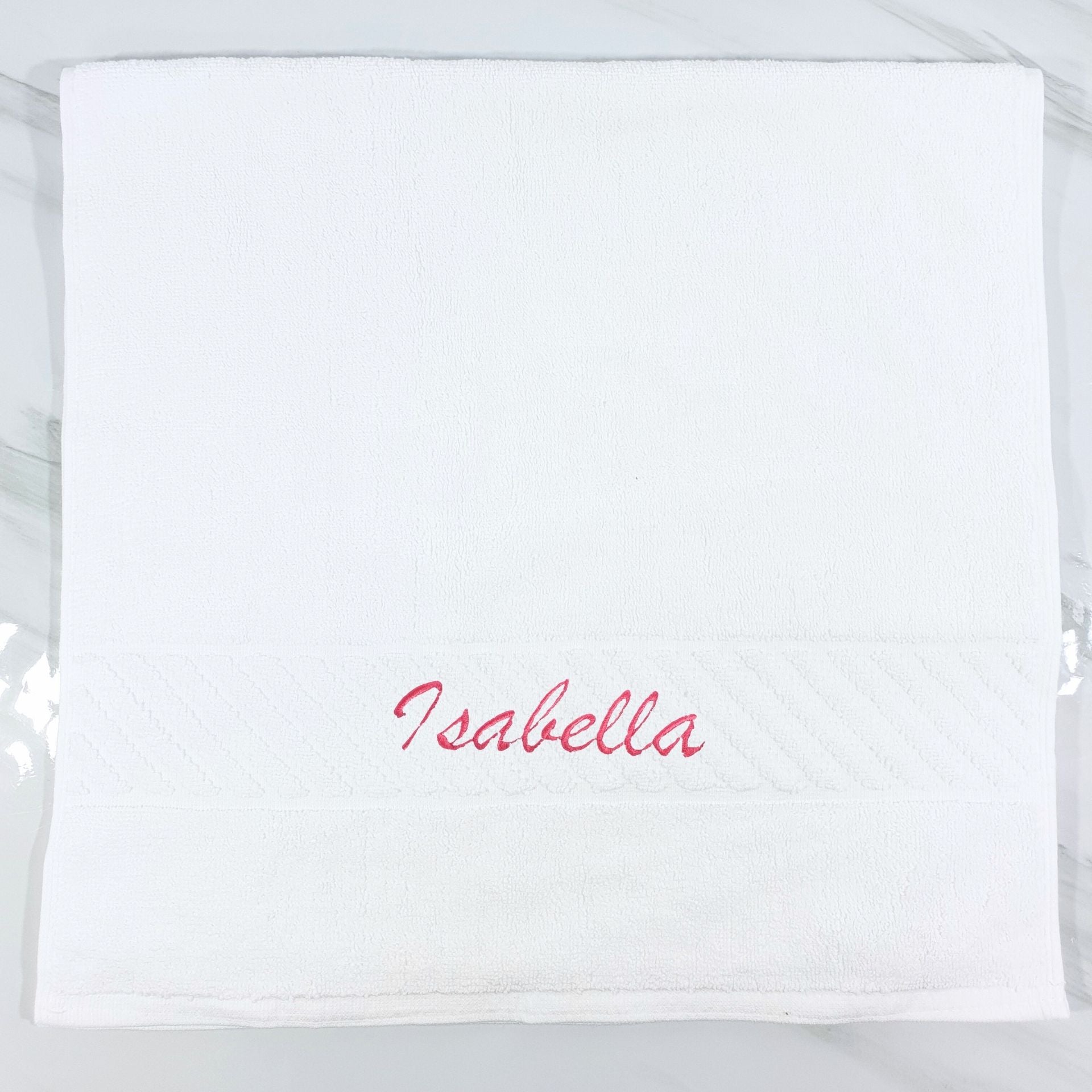 White hand towel with 'Isabella' embroidered in red on a white background